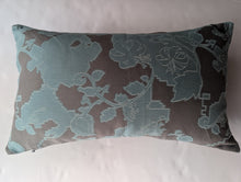 Cargar imagen en el visor de la galería, A rectangular lumbar throw pillow featuring a muted teal and dark brown jacquard floral pattern, shown against a light textured background.